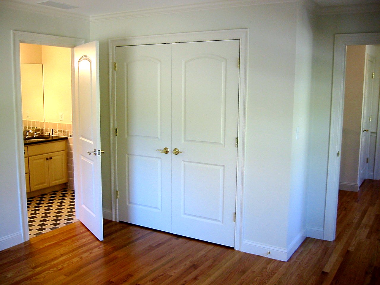 Bedroom with paneled double closet doors and an en-suite bath