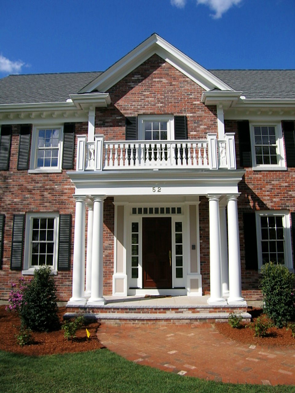Brick Georgian with a two-story columned portico, balustrade and pedimented gable