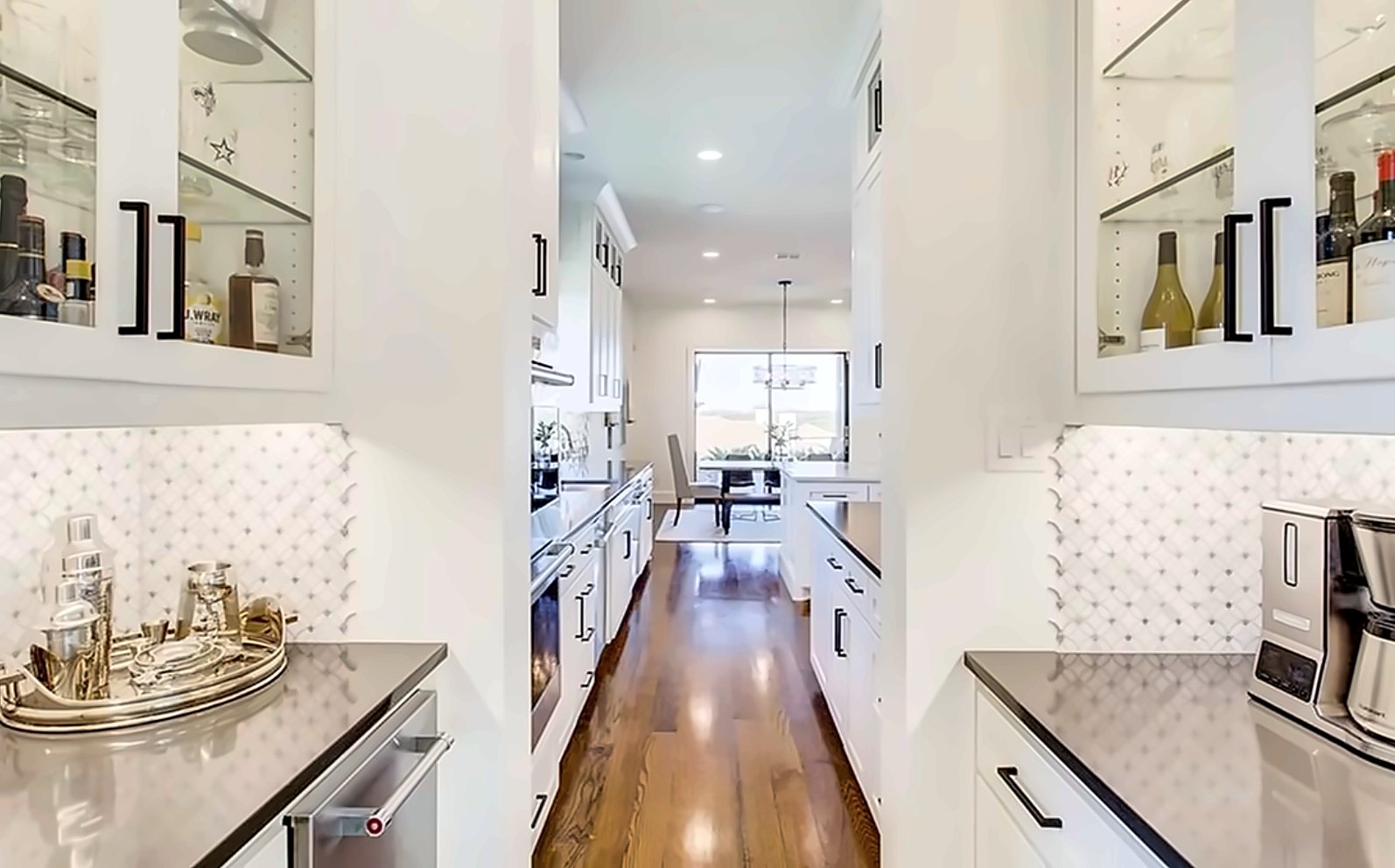 Butler's pantry with glass-front cabinets opening to the kitchen
