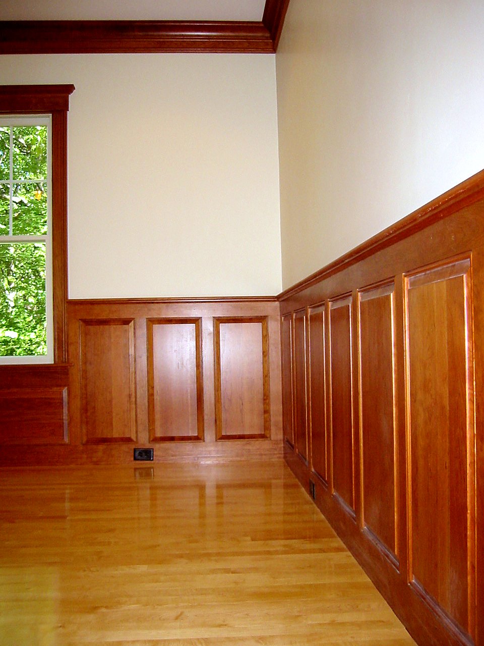 Cherry raised-panel wainscot with matching window casing and crown