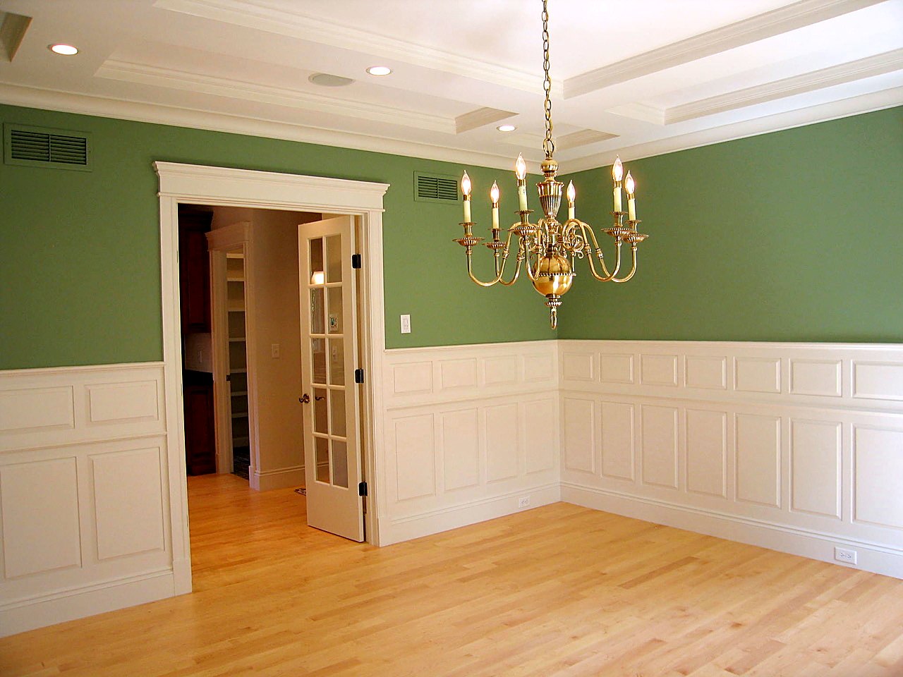 Dining room with raised-panel wainscot, coffered ceiling and brass chandelier