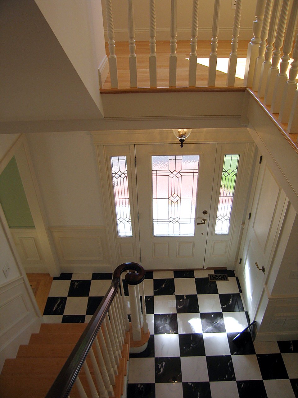 Foyer from above with a checkerboard marble floor and leaded-glass entry