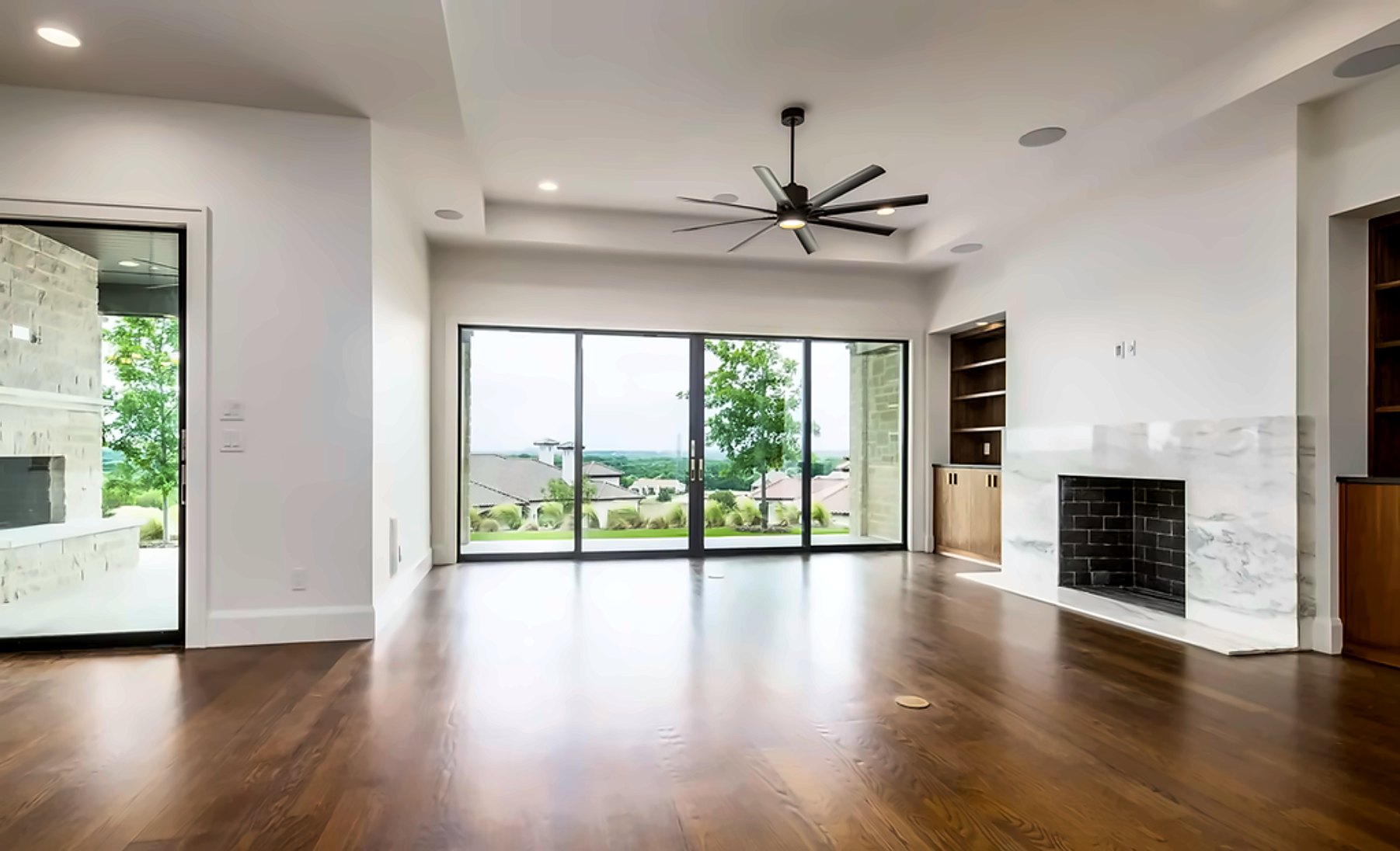 Living room with a marble fireplace and a wall of sliding glass