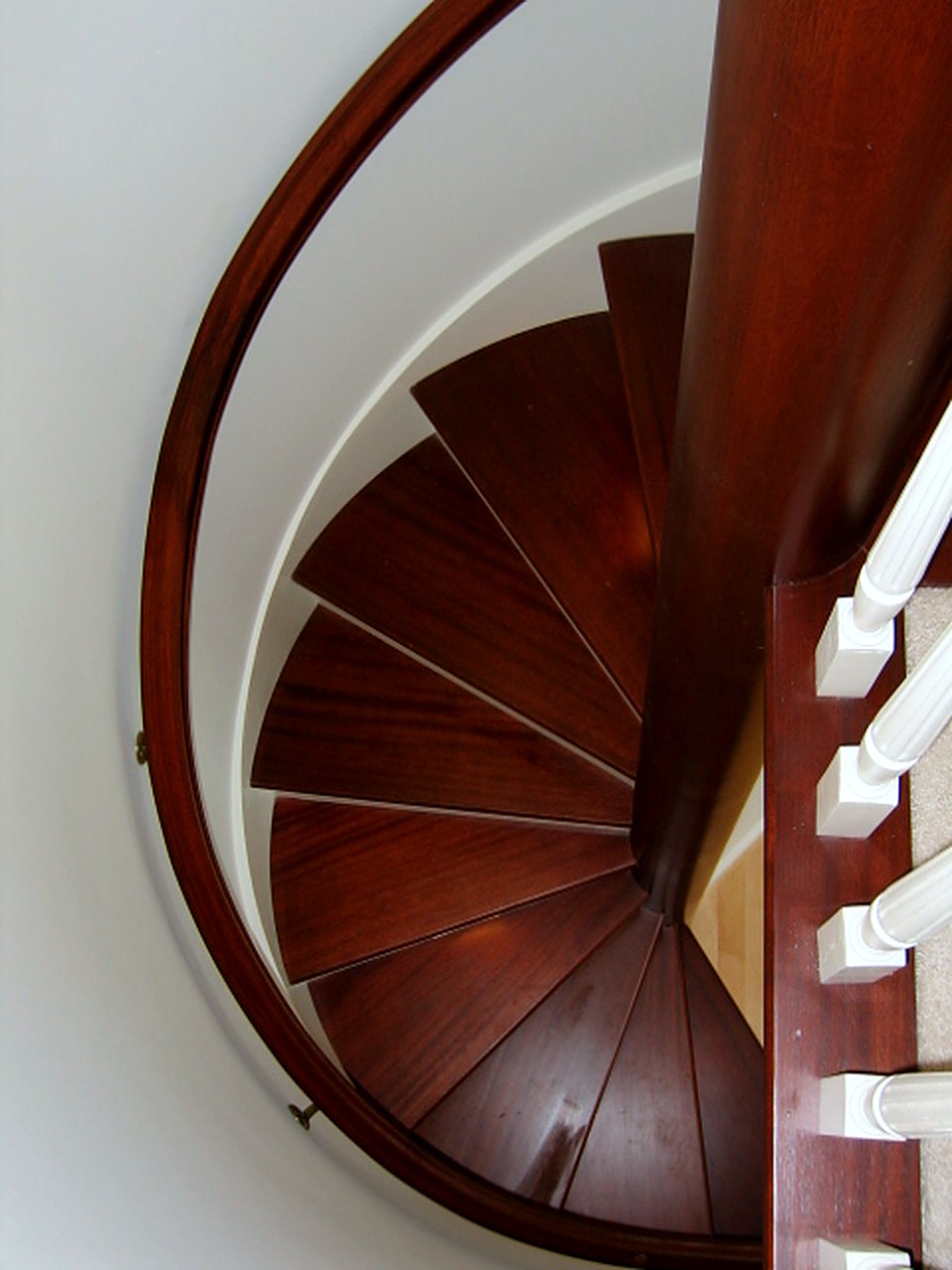 Mahogany spiral stair seen from above with a curved handrail