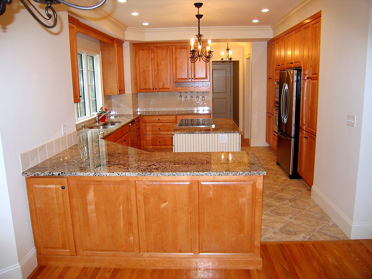 Maple kitchen with a granite peninsula, center island and wall of pantry cabinets