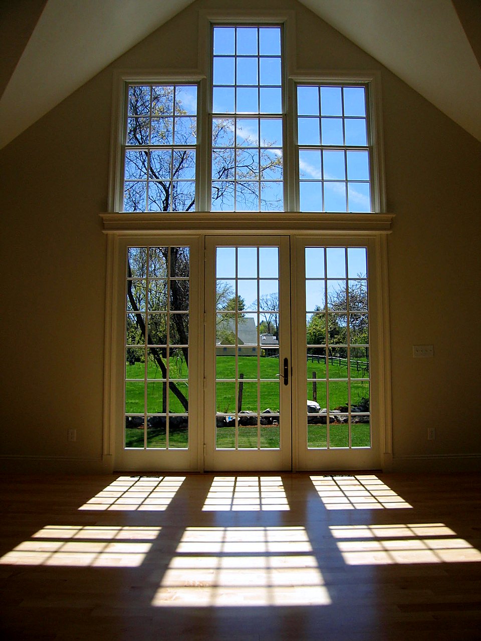 Vaulted room with stacked gable windows over triple French doors